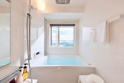 白滨Crystal Exe Nanki Shirahama 1的白色的浴室设有浴缸和窗户。