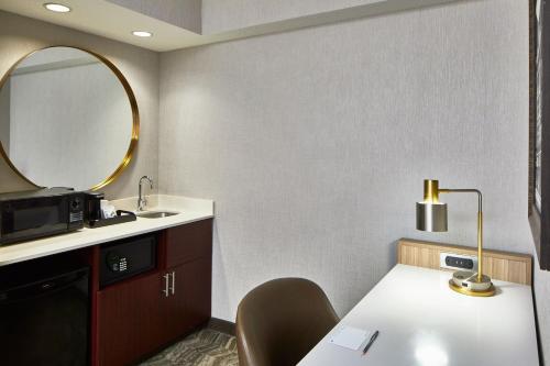孟菲斯孟菲斯市中心春季山丘套房酒店的一间带水槽和一张带镜子的桌子的浴室