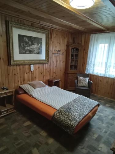 WilczeMarianówka的一间卧室配有一张大床和一把椅子