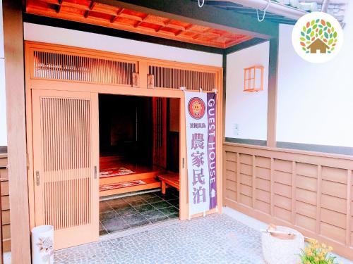 高岛市Farm stay inn Sanzaemon-tei 母屋GuestHouse Shiga-Takasima Traditional Japanese architecture house的一座建筑,上面有标志