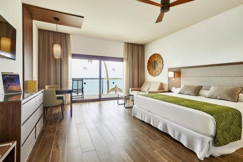 妮兰朵南环礁Riu Palace Maldivas- All Inclusive的酒店客房设有一张大床和一张桌子。