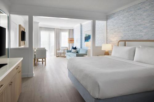 贝瑟尼滩伯大尼海滩海洋套房 - 万豪原住客栈的一间带大床的卧室和一间客厅