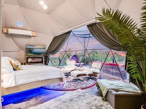 Lago VistaUdoscape Eco-Glamping Resorts的一间卧室,配有带床和植物的帐篷