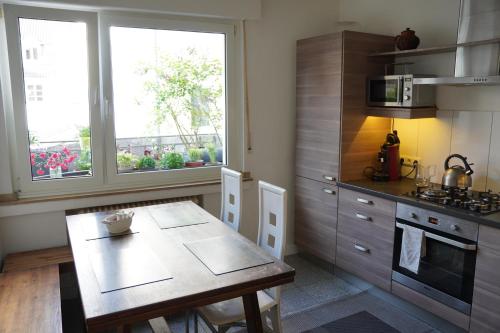 亚琛Bright, spacious apartment with a lovely terrace in the heart of Aachen的厨房配有桌子、炉灶和窗户。