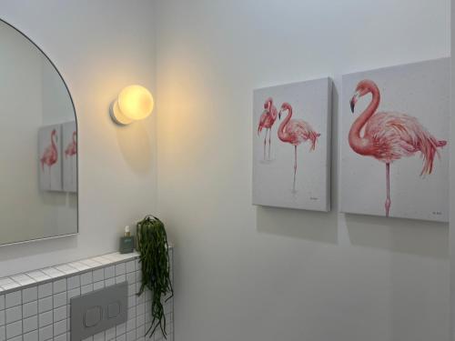 BrightonModern Pool Oasis & Seaside Abode的浴室墙上有3个粉红色火烈鸟