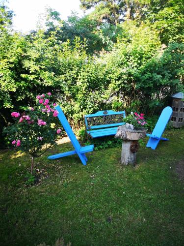 柏林Pension zum Sägebock的两把蓝色的椅子和院子内的长凳