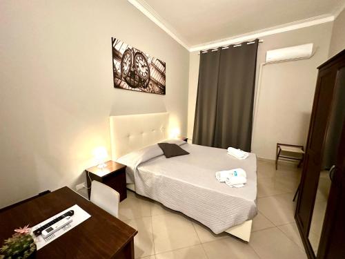 米兰Golden Milano Hotel的酒店客房配有一张床铺、一张桌子和一张书桌。