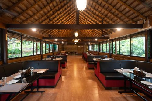 哥印拜陀Ibex River Resort, Pollachi的用餐室设有桌椅和窗户。