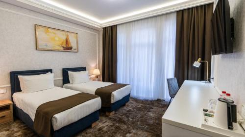 塔什干Garnet Mir Hotel的酒店客房配有两张床和一张书桌