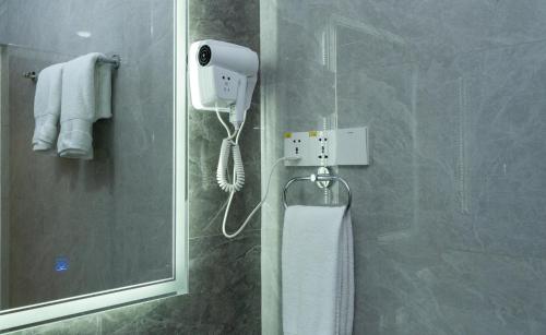 塔什干Garnet Mir Hotel的带淋浴的浴室,墙上配有电话