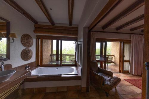 卡帕玛私人野生动物保护区卡帕玛河山林小屋的带浴缸和椅子的大浴室