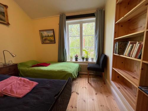 斯德哥尔摩Bed&Breakfast in nature 12 min from city free bikes的一间卧室设有两张床、一个窗口和椅子