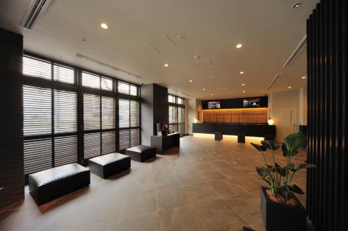 名古屋多美迎PREMIUM名古屋荣酒店的大楼内带钢琴的客厅
