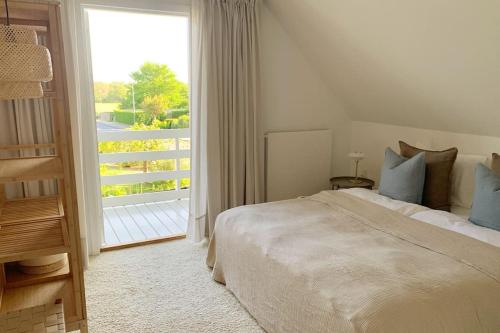 福堡Lovely villa at the foot of the Funen Alps的一间卧室设有一张床和一个大窗户