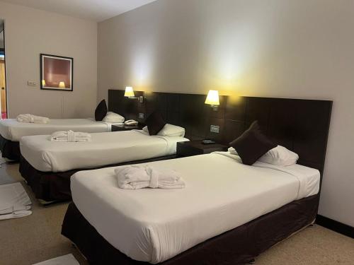 阿布扎比阿詹辛拉俱乐部酒店的酒店客房,配有3张带白色床单的床
