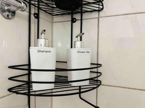 哈根Nordsee Appartement in Hagen的浴室里带两个肥皂分配器的黑色金属架