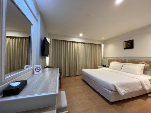 南府黛瓦拉奇酒店的一间设有大床和窗户的酒店客房