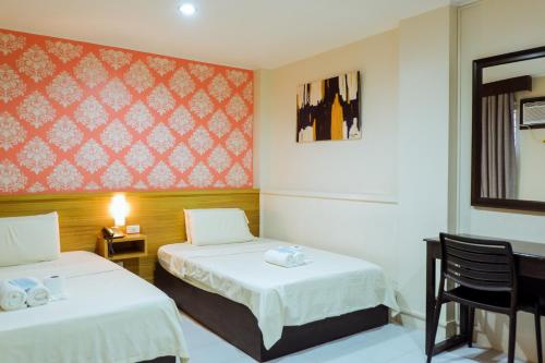 马尼拉利亚诺酒店的酒店客房设有两张床和窗户。