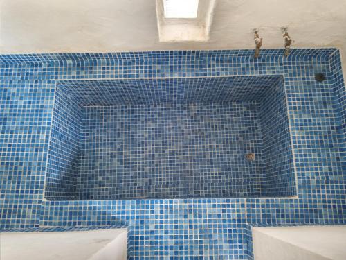 古莱比耶Maison de vacance pour les amateurs de la nature的浴室设有蓝色瓷砖浴缸。