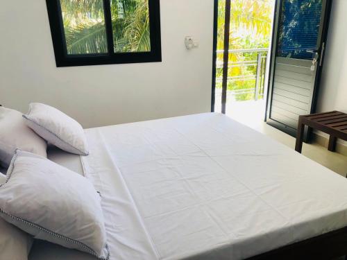 马哈赞加Hôtel Tropicana Majunga的一张带白色床单和枕头的床