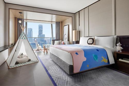 上海上海鲁能JW万豪侯爵酒店的一间卧室配有一张大床和一个游乐帐篷