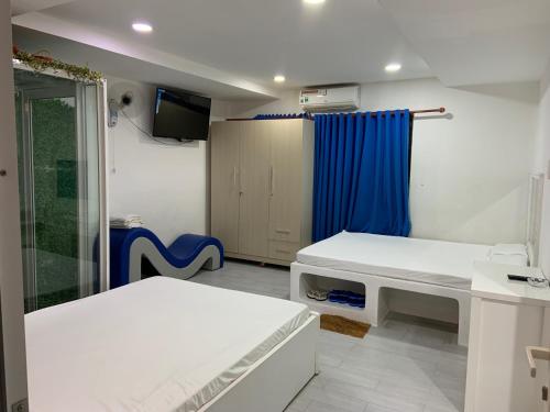 Tây NinhHotel MAI TUAN Chánh Môn A的一间设有两张床和蓝色窗帘的房间