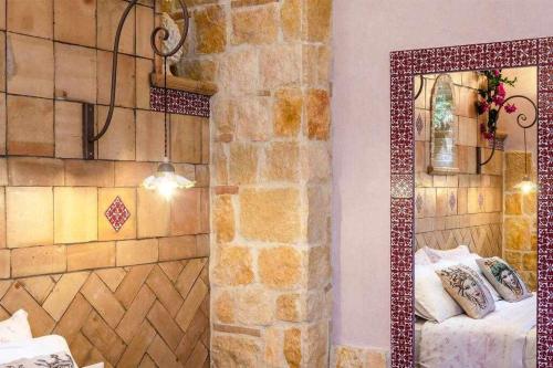 加里Casa della Giara的一间卧室设有石墙和镜子