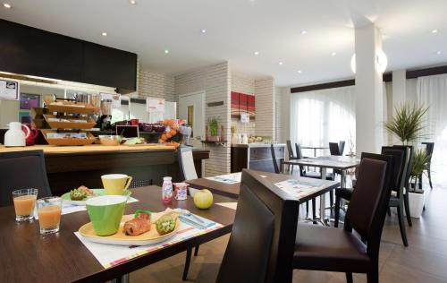贝尔福宜必思式贝尔福中心酒店的厨房以及带桌椅的用餐室。