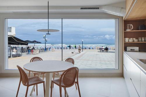 扎鲁亚斯Kein Hostel的配有桌椅的厨房,享有海滩美景