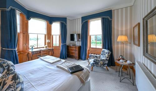 纽马基特The Jockey Club Rooms的一间卧室配有一张床、一张桌子和一把椅子