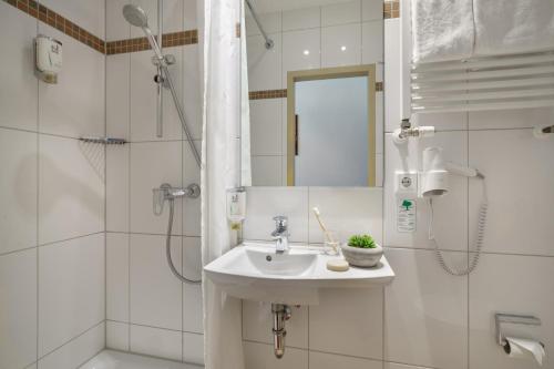 汉堡格拉夫莫尔汉堡新奇酒店的白色的浴室设有水槽和淋浴。