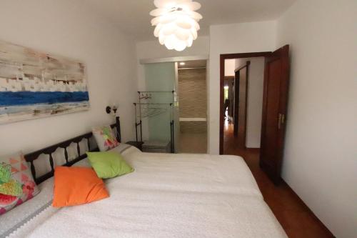坎布里尔斯Planta baja, primera linea, playa, jardín privado, Ardiaca, Cambrils, apartamento Jacqueline的卧室配有一张带彩色枕头的大型白色床。