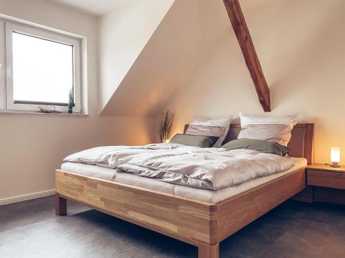 SchwanewedeFEWO Leuchtturmidyll Harriersand的一间卧室配有一张木床和窗户