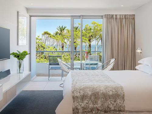 开普敦South Beach Camps Bay Boutique Hotel的一间卧室配有一张床,一间享有美景的用餐室