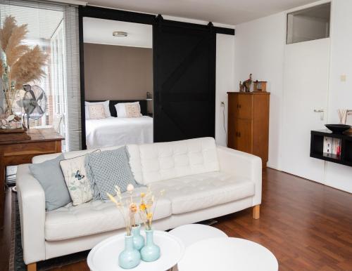 阿珀尔多伦Center Appartement Apeldoorn的客厅配有白色的沙发和床。