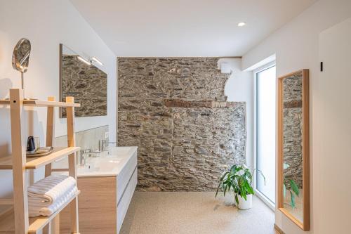 布尔格-罗伊兰德B&B - La Maison des Sottais的一间带石墙和水槽的浴室