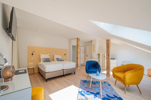 布尔格-罗伊兰德B&B - La Maison des Sottais的一间卧室设有一张床和一间客厅。