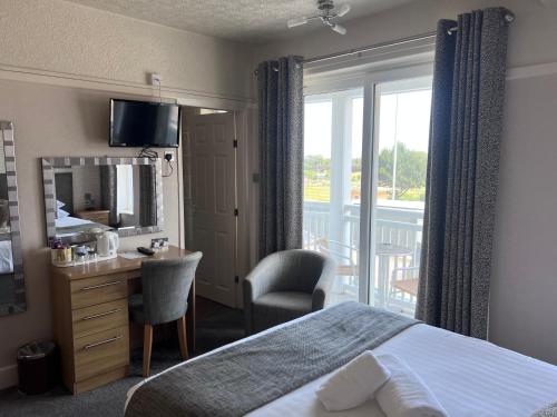 斯凯格内斯萨沃伊酒店的酒店客房设有一张床、一张书桌和一个阳台。