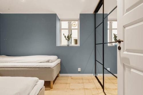 卑尔根Dinbnb Apartments I Luxury Feel 100m from Bryggen的一间卧室设有两张床和蓝色的墙壁