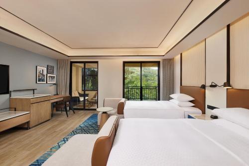 琼中海南琼中福朋喜来登酒店的酒店客房设有两张床和电视。