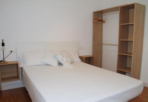 代尔特布雷Antich Apartment Deltebre的一张带白色床单和枕头的床