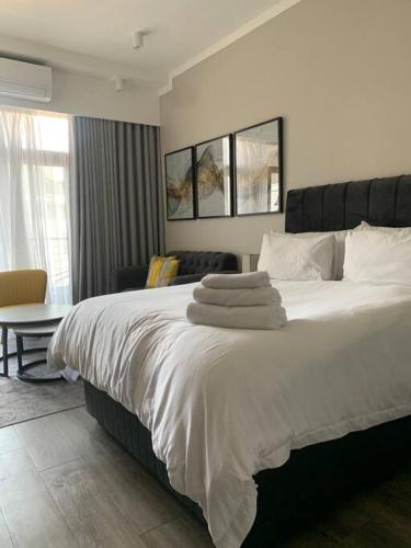 比勒陀利亚Entire Studio Apartment @MenlynMaine的卧室配有一张带白色床单和枕头的大床。
