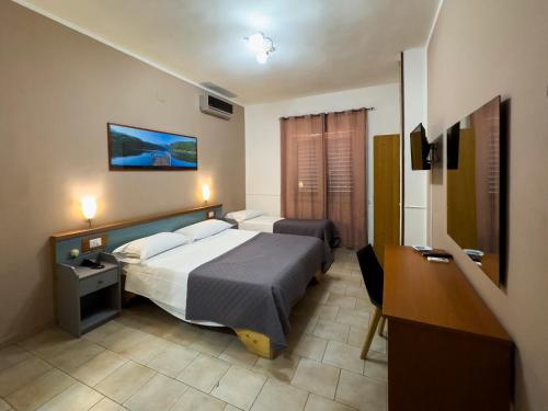 那不勒斯马提尼酒店的酒店客房设有两张床和电视。