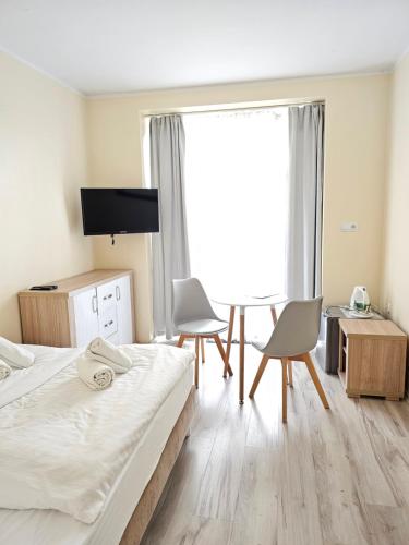 斯维诺乌伊希切Lazur Apartamenty的一间卧室配有一张床、两把椅子和电视