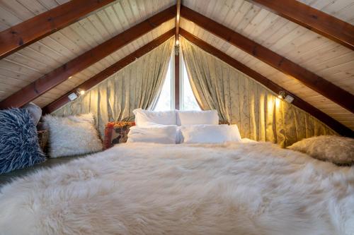 Nimrodהטירות הנעות ברוח的卧室配有一张大白色床和窗户