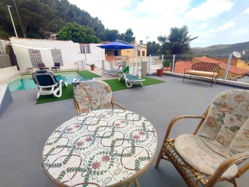 甘迪亚VILLA FALCONERA APARTAMENTS, GANDIA a las faldas de la montaña的一个带桌椅的庭院和一个游泳池