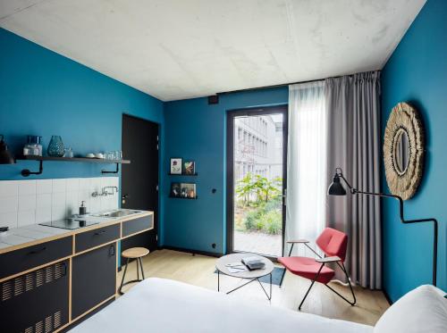 巴黎Deskopolitan House的一间卧室设有蓝色的墙壁、水槽和两把椅子