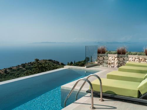 ExanthiaAnadeo Villas & Suites的游泳池旁设有绿色躺椅