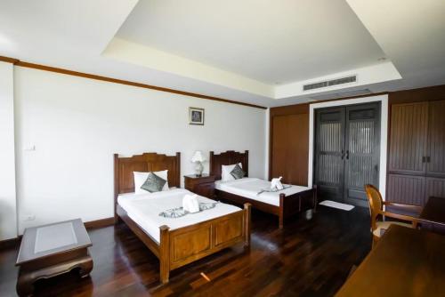 象岛Kooncharaburi Resort - Koh Chang的酒店客房设有两张床和一张桌子。