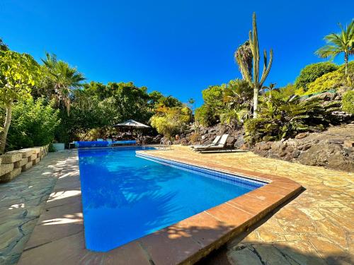 吉亚德伊索拉Tropical Garden Finca的度假村内的一个蓝色海水游泳池